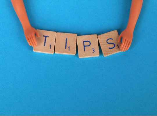 Hands holding tiles spelling out the word tips