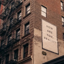Poster on side of building that says "how are you, really?"